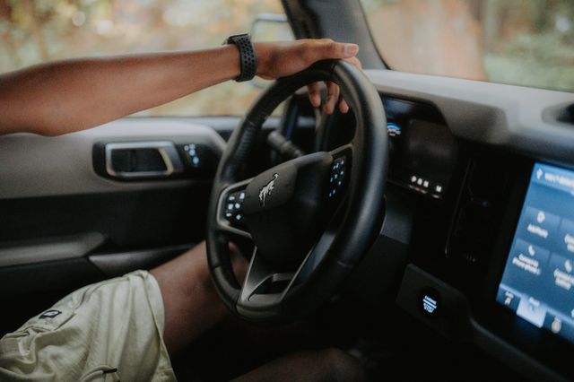 Ruka vozača na volanu automobila sa vidljivim pametnim satom